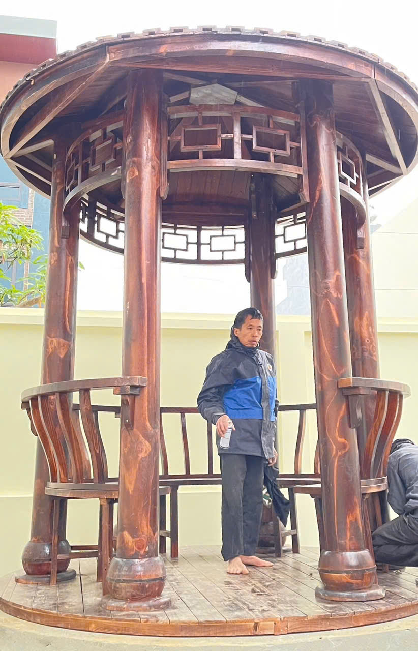 Thợ đang sơn phủ lại bề mặt gỗ cho chòi